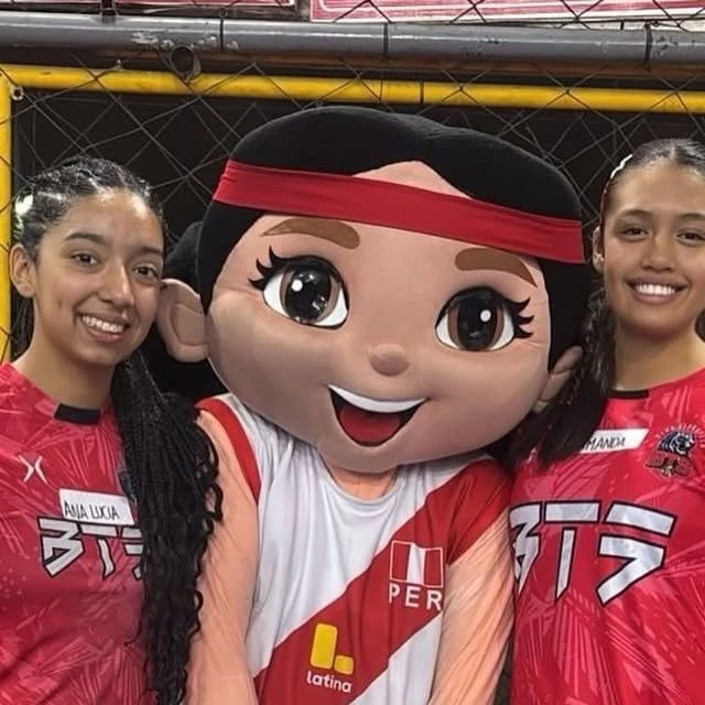Dos jugadoras del Club Deportivo BTS posan junto a la mascota Latinita